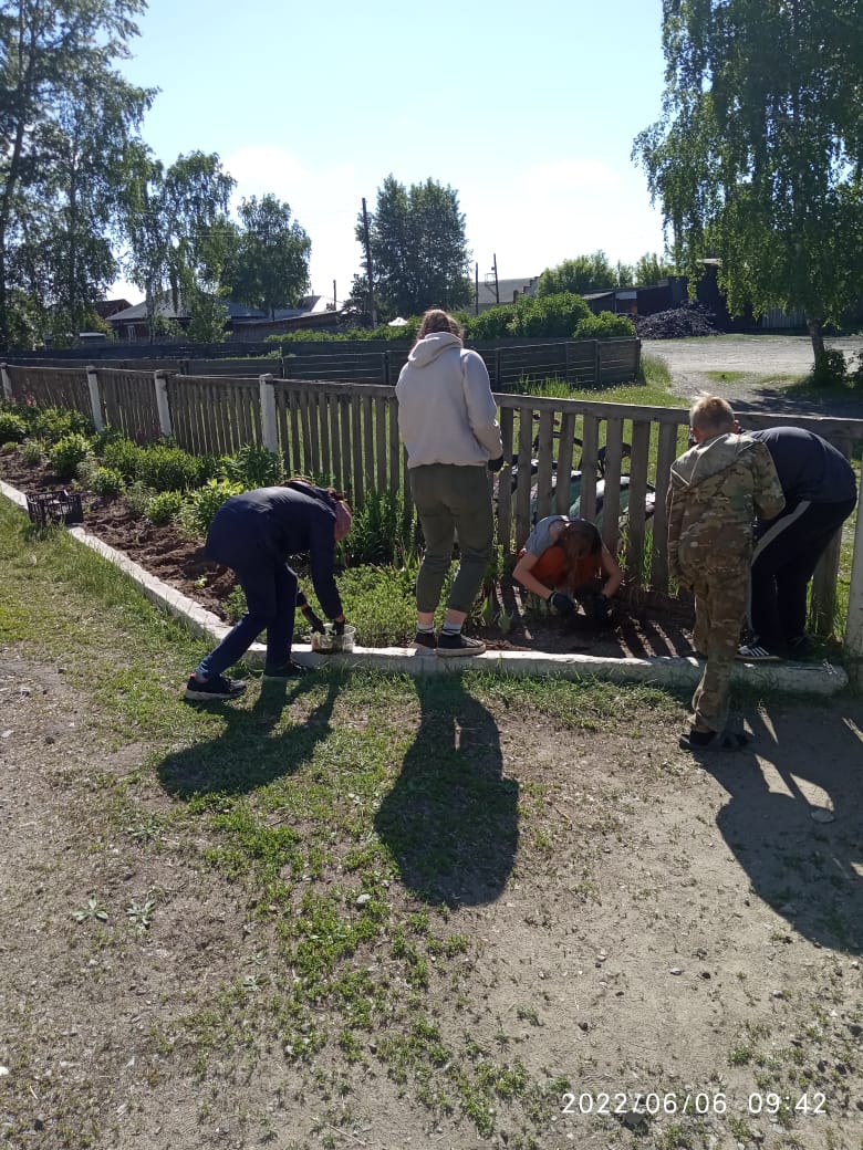 Дети ухаживают за пришкольными клумбами.